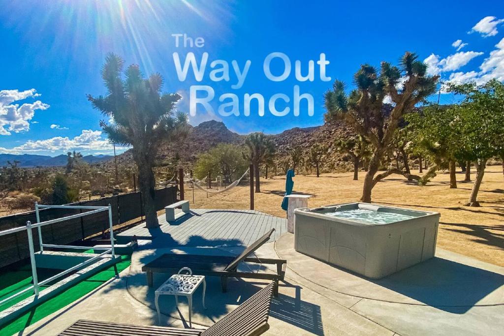 Un patio con jacuzzi y árboles y las palabras "way out ranch" en Romantic Secluded Hot Tub Fire Pit, en Joshua Tree