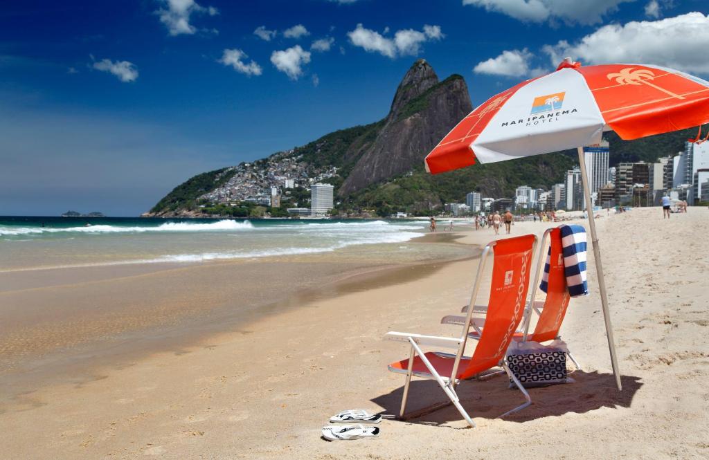 uma praia com duas cadeiras e um guarda-sol em Mar Ipanema Hotel no Rio de Janeiro