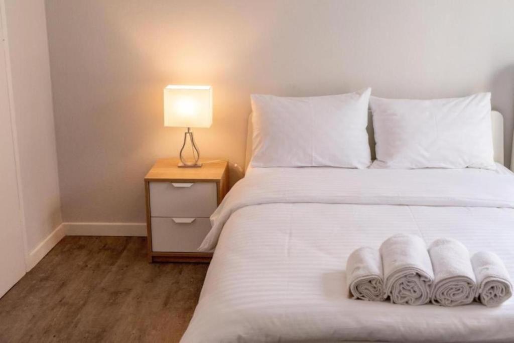 a bedroom with a white bed with towels on it at Nice & Cozy Apartments in Alexandroupoli