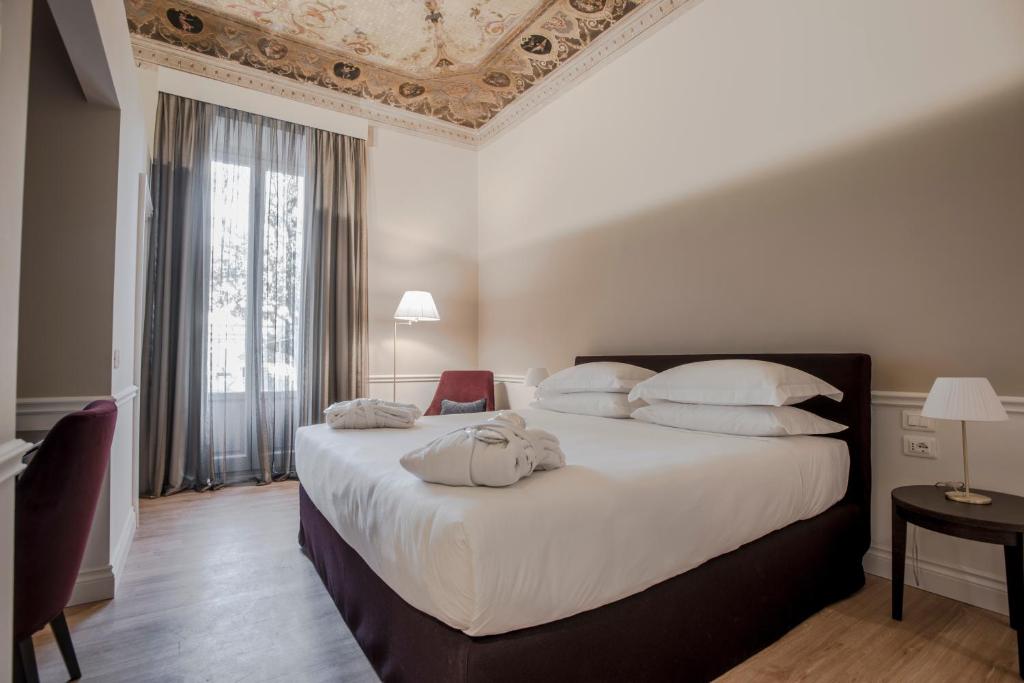 Een bed of bedden in een kamer bij Palazzo Castri 1874 Spa & Garden
