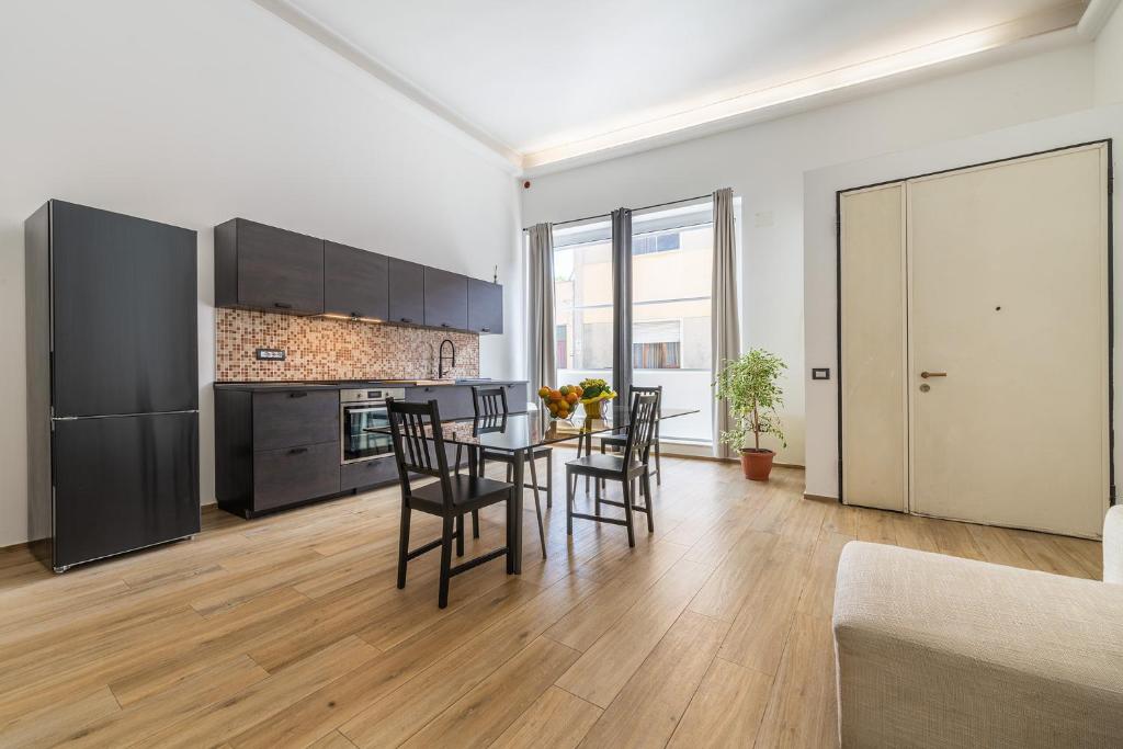 a kitchen and dining room with a table and chairs at Loft Eleonora D’Arborea in Quartu SantʼElena