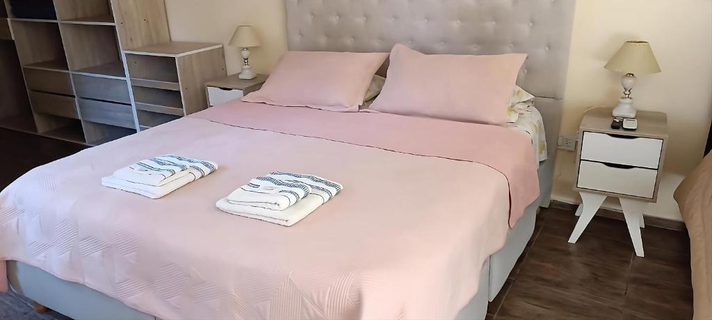 a bedroom with a white bed with towels on it at Casa Olivia- Alojamiento con piscina - Aeropuerto Ezeiza in Ezeiza