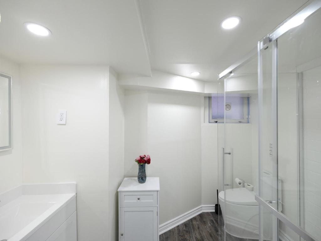 a white bathroom with a toilet and a shower at Serene Niagara Inn in Niagara Falls