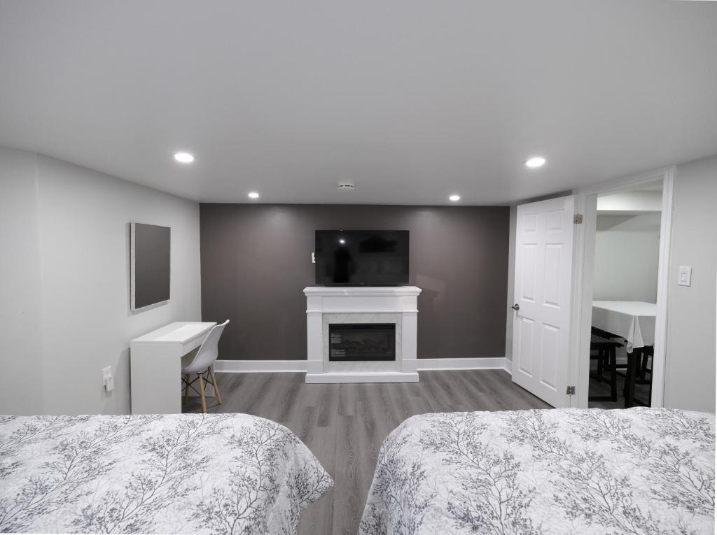 a bedroom with two beds and a fireplace and a tv at Serene Niagara Inn in Niagara Falls