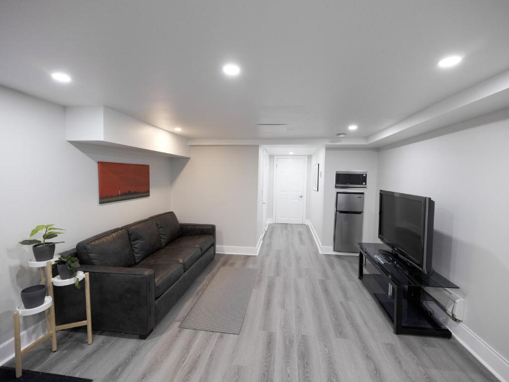 a living room with a couch and a flat screen tv at Serene Niagara Inn in Niagara Falls