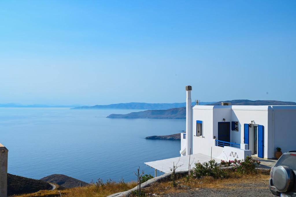 a white building next to a body of water at Theros House Kythnos in Kithnos