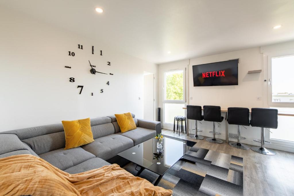 a living room with a couch and a clock on the wall at Large 4 Bedroom Apartment near metro - only 30 minutes to Paris and Disneyland in Créteil