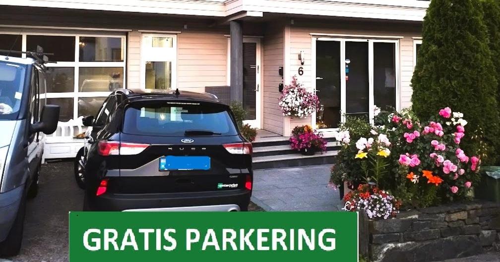 a car parked in front of a house with flowers at Villa Baneheia-Studios & Apartment in Kristiansand