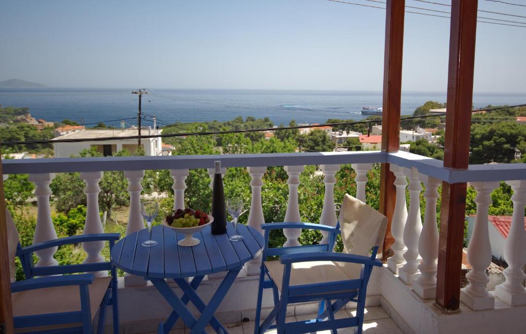 a table and chairs on a balcony with a view of the ocean at Myriam Studios in Patitiri