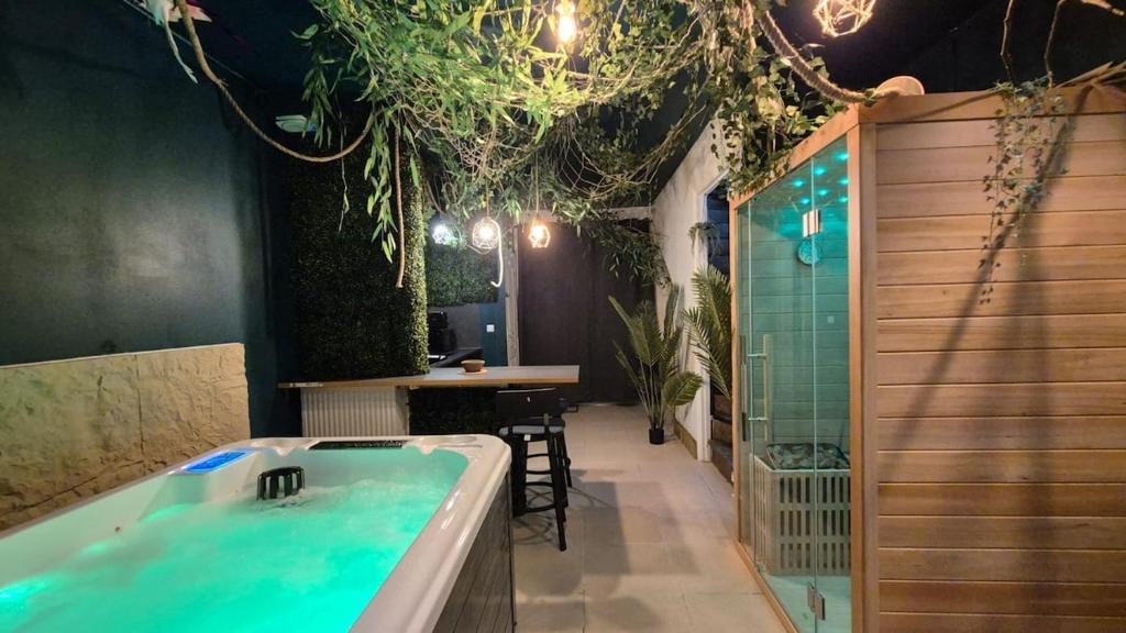 a bathroom with a tub and a table with chairs at Botanica - Private Spa in Saint-Quentin