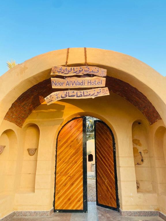 a building with a door with a sign above it at Nour El wadi in Siwa