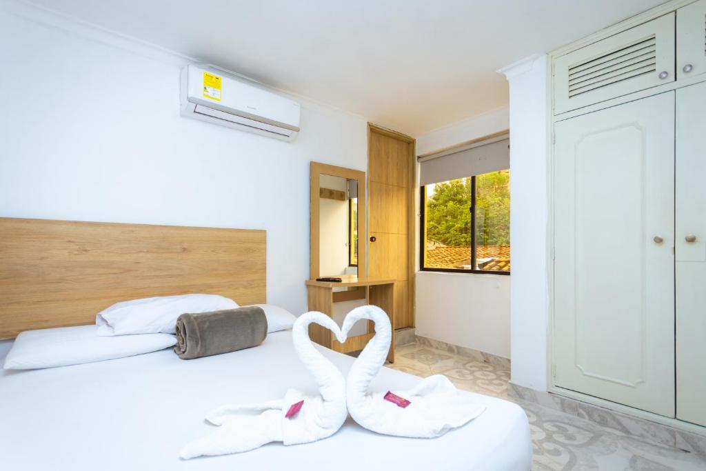 a bedroom with two swans in the shape of a heart at Hotel Colores Boutique in Medellín