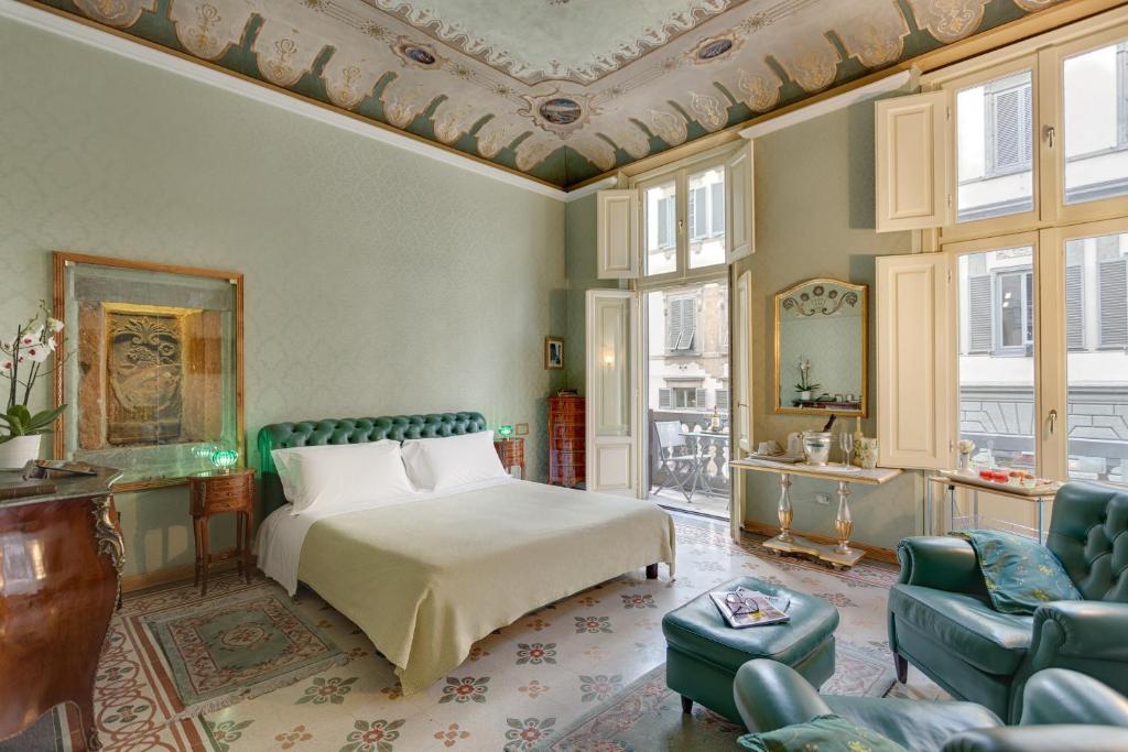 a bedroom with a bed and a couch and chairs at B&B Cavour10 Firenze in Florence