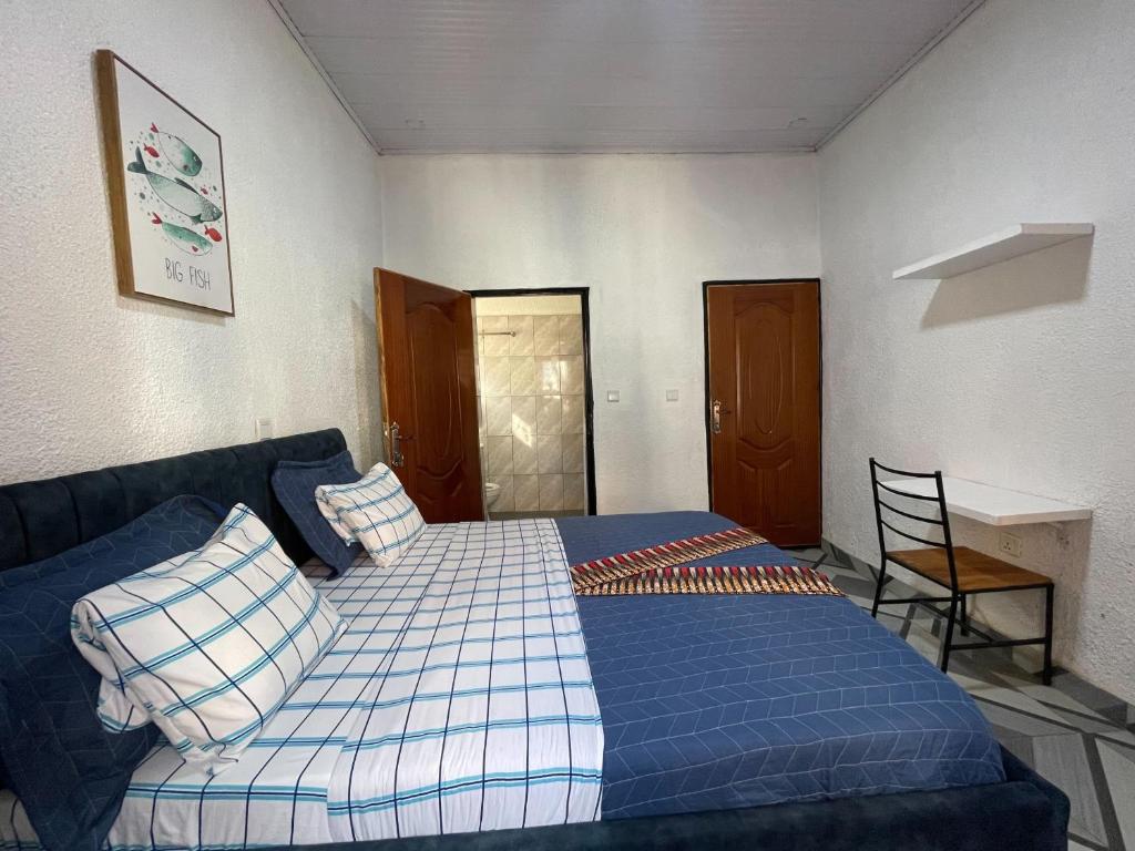 een slaapkamer met een blauw bed en een stoel bij Tivana in Kigali