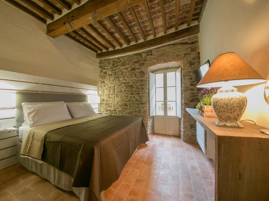 a bedroom with a bed, a desk, and a window at Casa Zeni in Cortona