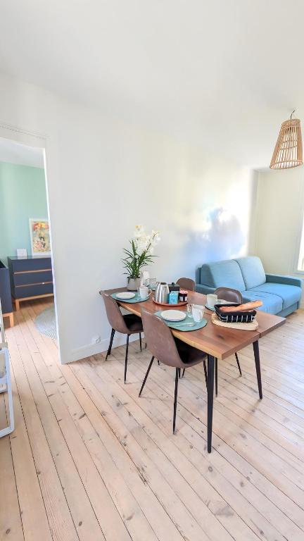 un salon avec une table et un canapé bleu dans l'établissement Il Nido 2, F2 hyper centre, parking et wifi, à Villers-sur-Mer