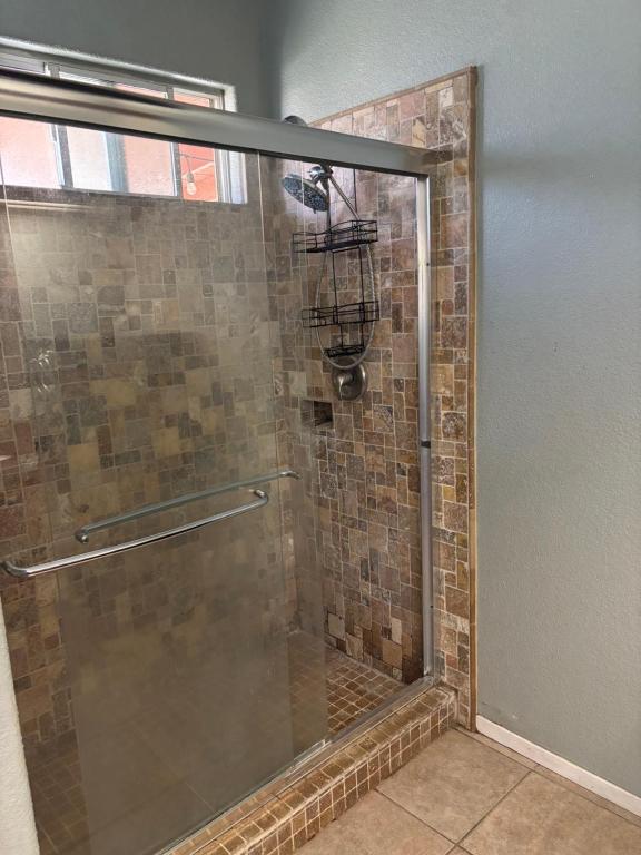 a shower with a glass door in a bathroom at Master bedroom in Bakersfield