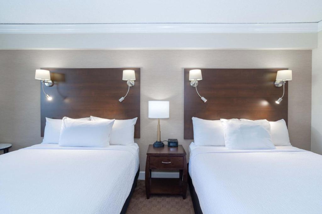 two beds in a hotel room with white pillows at Sandman Signature Vancouver Airport Hotel & Resort in Richmond