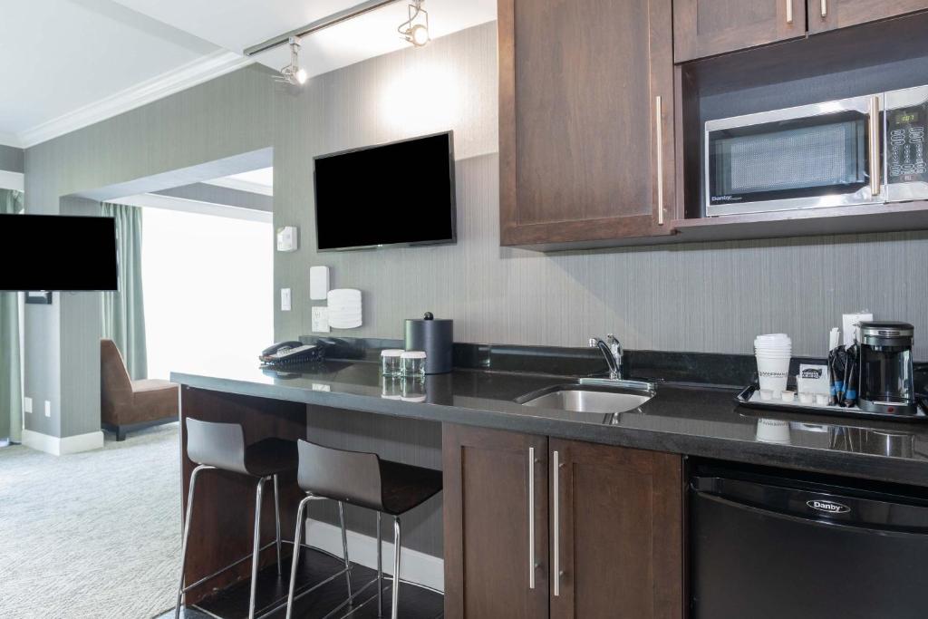 a kitchen with a counter with a sink and a microwave at Sandman Signature Vancouver Airport Hotel & Resort in Richmond