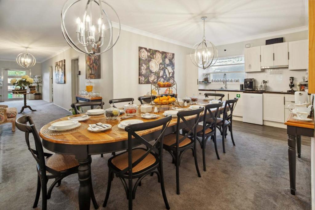 a dining room and kitchen with a table and chairs at Cypress BnB in Hervey Bay