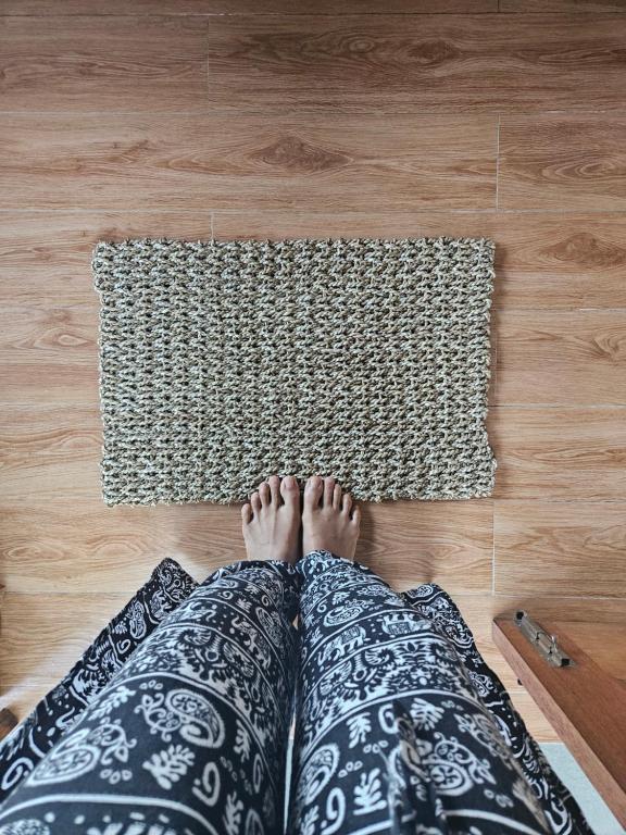 a person laying on the floor with their feet on a rug at Mantra Yoga Homestay in Tanjung
