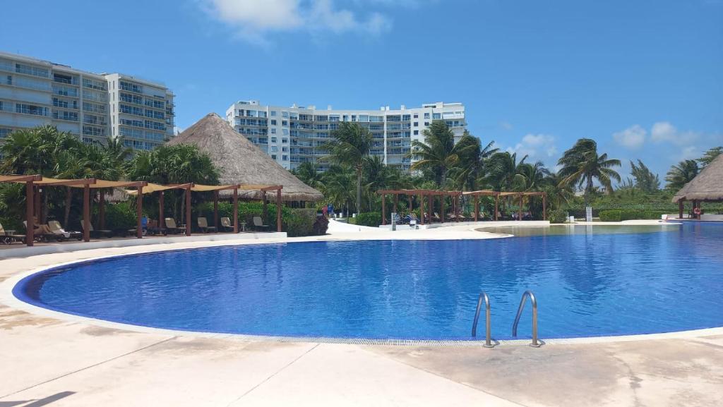 a large swimming pool with umbrellas in a resort at Beachfront apartments Cancun in Cancún