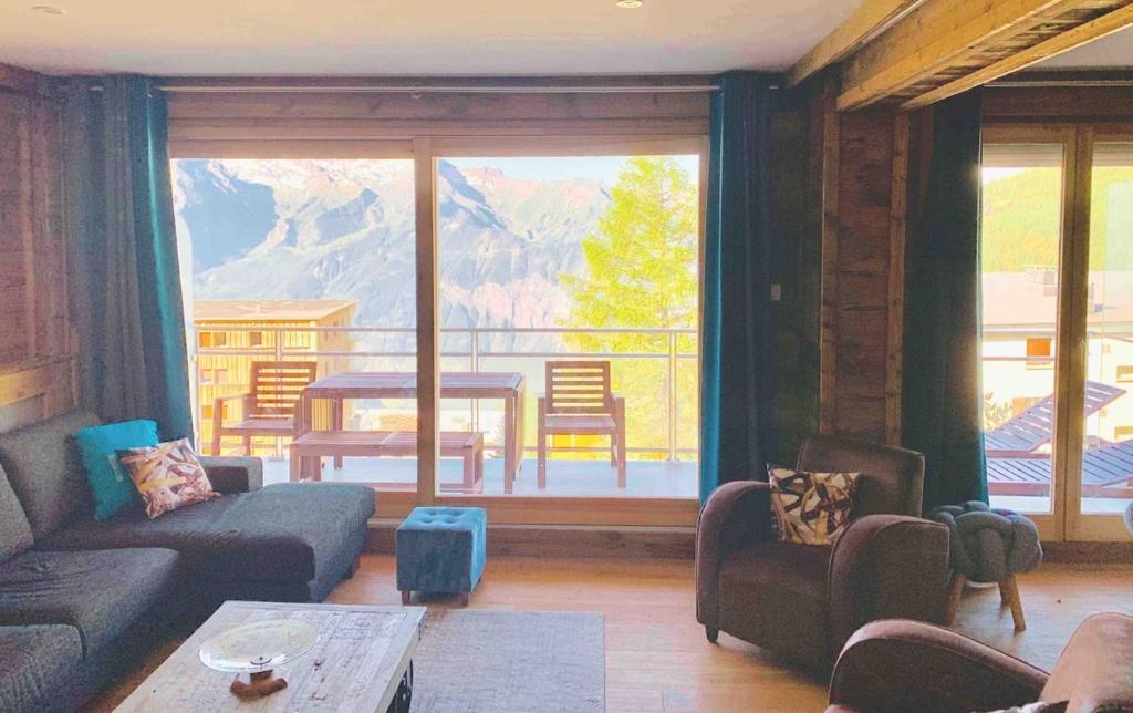 - un salon doté d'une grande fenêtre offrant une vue sur la montagne dans l'établissement B2 Superbe apart Ski au pied Vue magnifique, à Huez