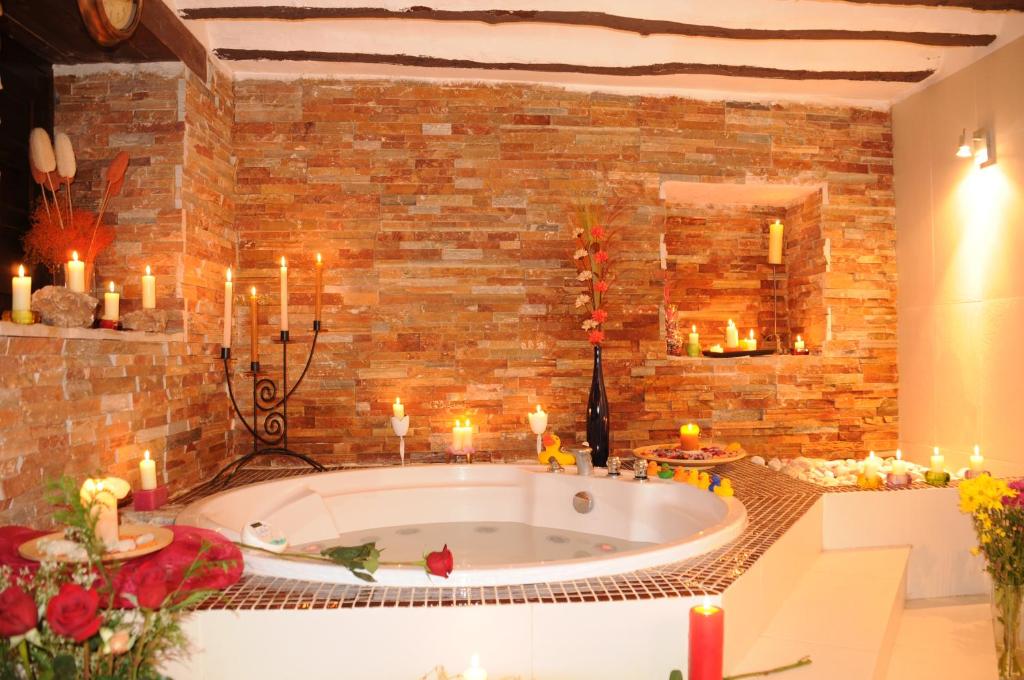 uma grande banheira num quarto com velas em Hotel La Casa del Canónigo em Caracenilla