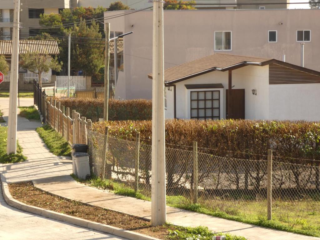 a fence with a pole next to a house at Cabañas Los Tamarindos in Algarrobo
