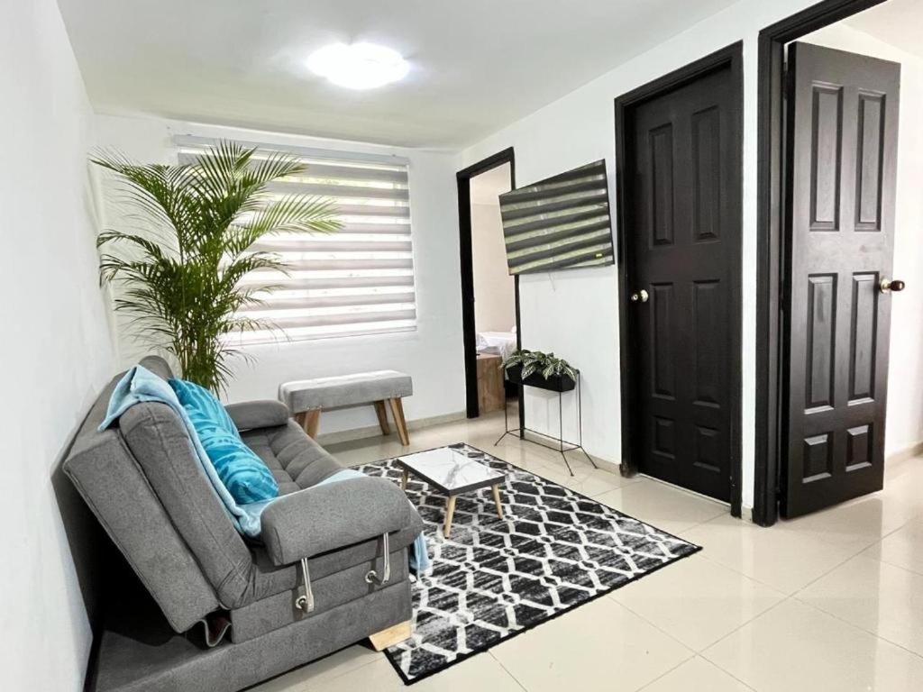 a living room with a couch and a black door at Apartamento confortable y tranquilo in Manizales