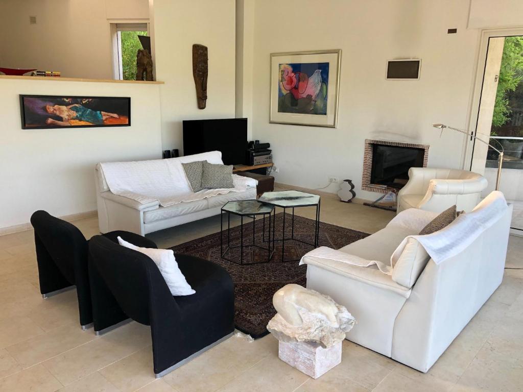 Elle comprend un salon doté d'un mobilier blanc et d'une cheminée. dans l'établissement Villa in La Croix-Valmer with Sea Views, cleaning included, à La Croix-Valmer