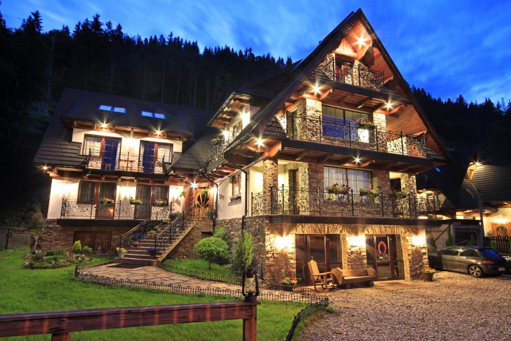 a large house with lights on the side of it at Dworek Pod Jodłami in Zakopane