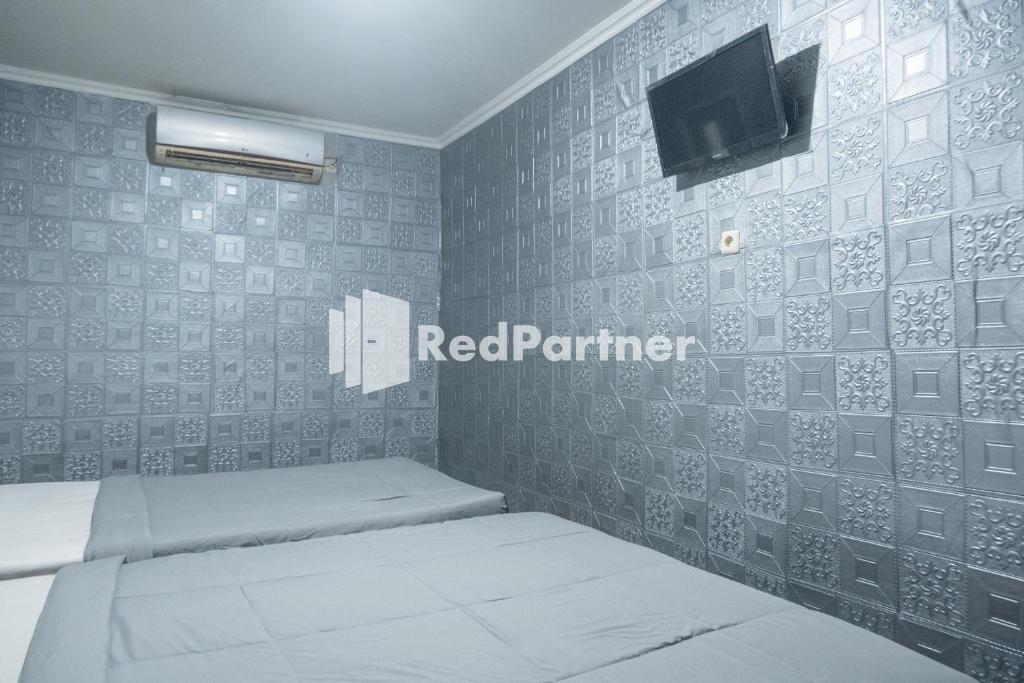 Postel nebo postele na pokoji v ubytování Crown Residence Hotel near Tugu Yogyakarta Mitra RedDoorz