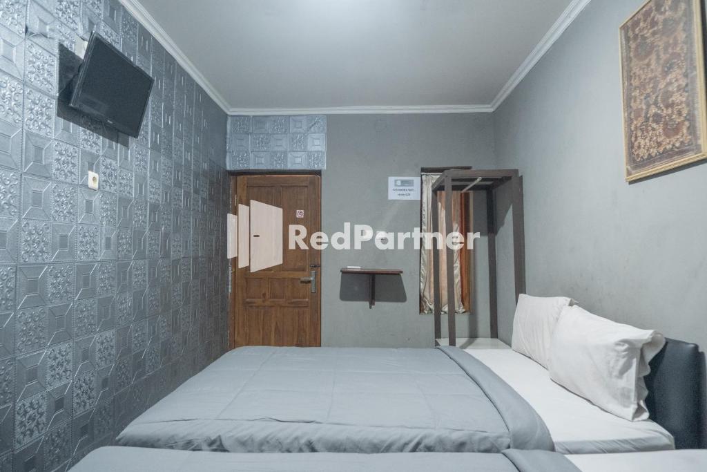 Postel nebo postele na pokoji v ubytování Crown Residence Hotel near Tugu Yogyakarta Mitra RedDoorz