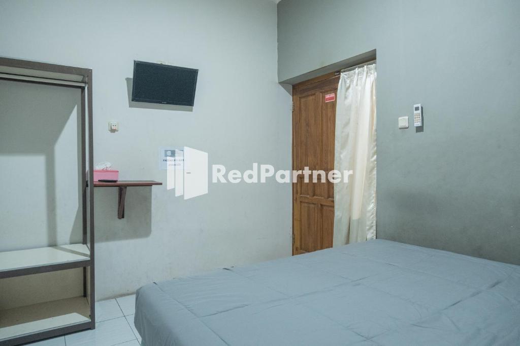 Postel nebo postele na pokoji v ubytování Crown Residence Hotel near Tugu Yogyakarta Mitra RedDoorz