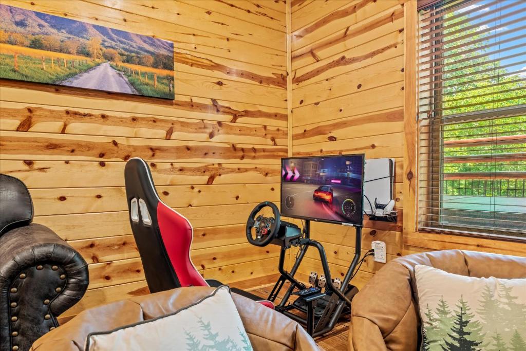 ein Wohnzimmer mit einem TV an einer Holzwand in der Unterkunft Pinot Splash in Gatlinburg