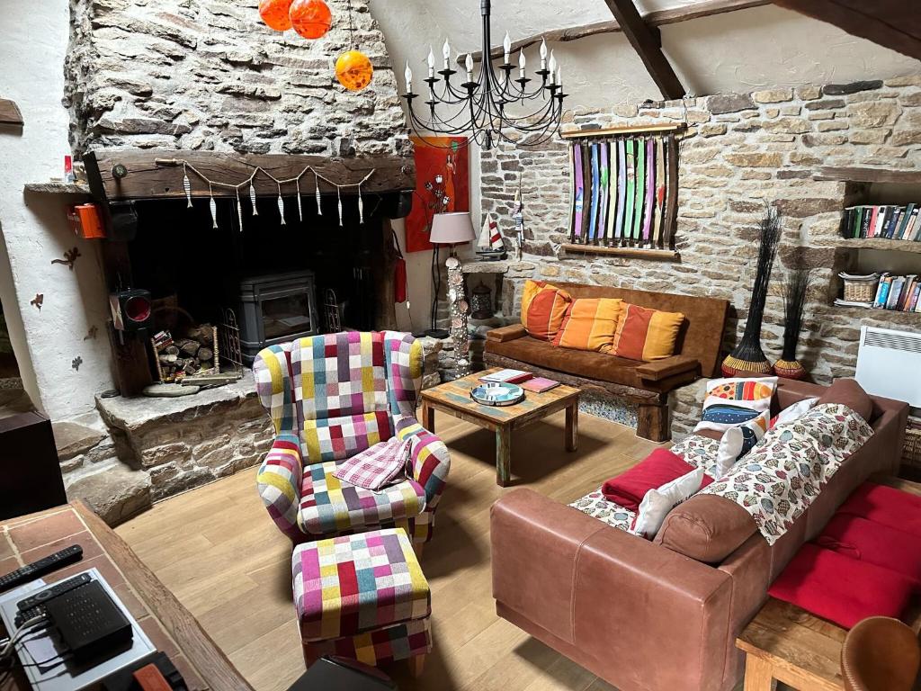 Elle comprend un salon doté d'un mobilier et d'un mur en pierre. dans l'établissement Holiday Home Coray near Sandy Beaches, cleaning included, à Coray