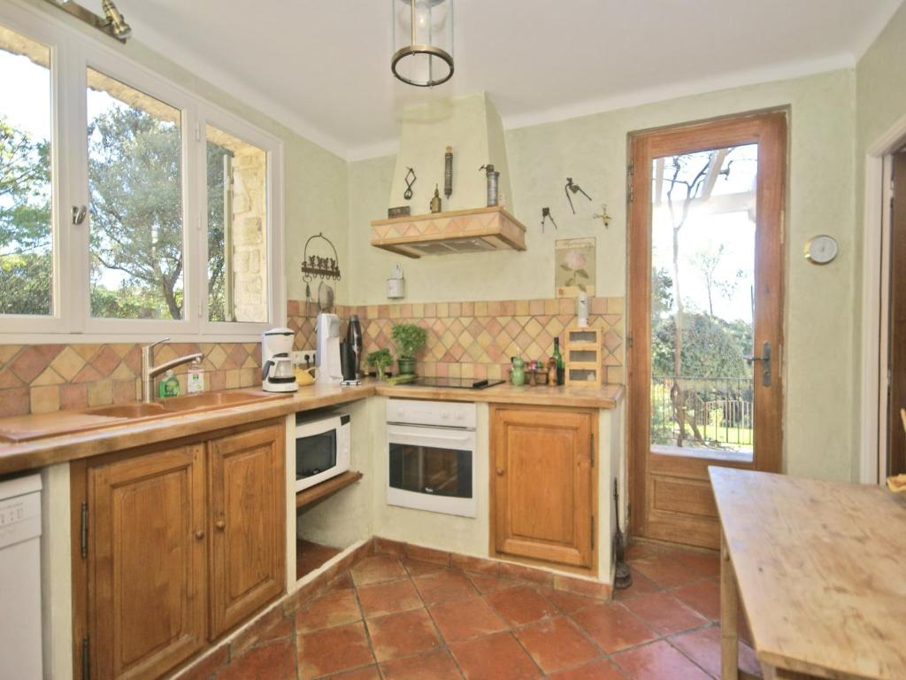 une cuisine avec des armoires en bois et une table à l'intérieur dans l'établissement Villa in Crillon-le-Brave near Mont Ventoux, cleaning included, à Crillon-le-Brave