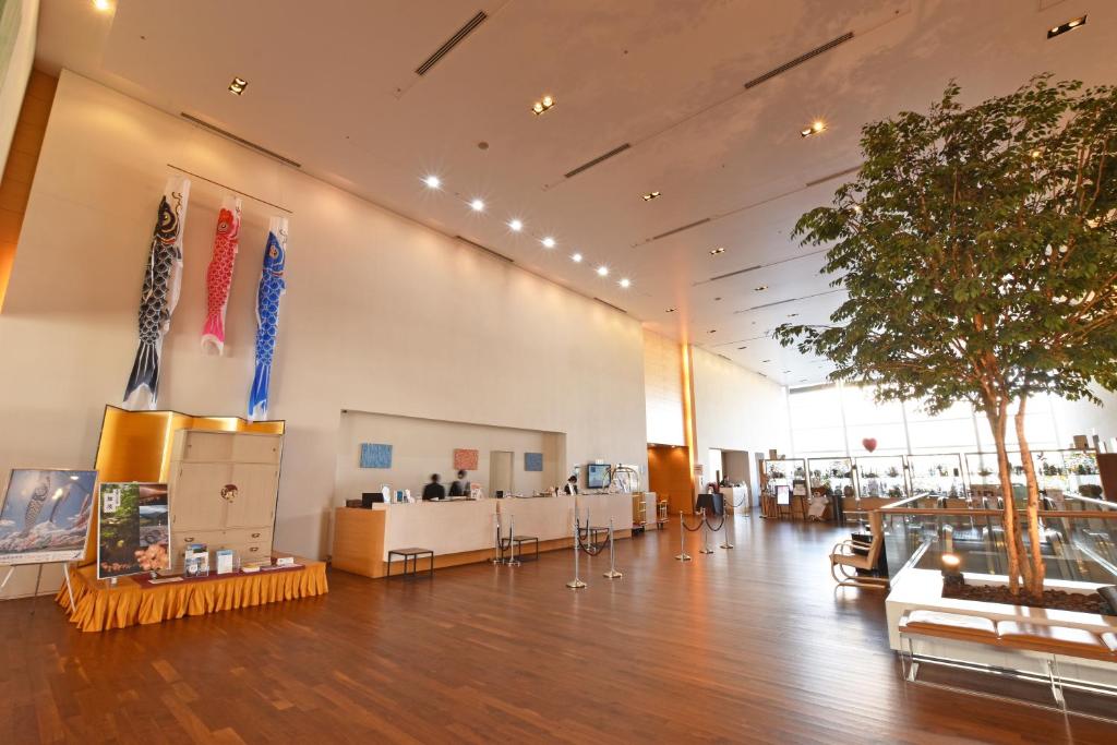 a large room with a lobby with a tree in it at Hotel Nikko Niigata in Niigata