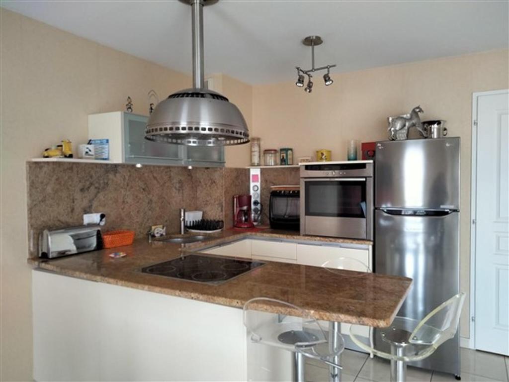 une cuisine avec un réfrigérateur en acier inoxydable et un comptoir dans l'établissement Duplex de Charme - Proche Plage, Port & Rues Piétonnes avec Parking Privé - FR-1-331-6, à Les Sables-dʼOlonne