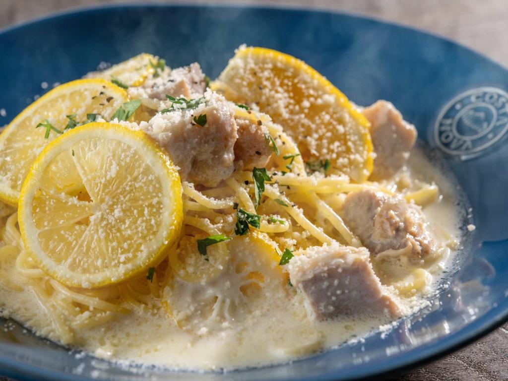 a blue plate of pasta with meat and lemon slices at Hotel Mystays Premier Akasaka in Tokyo