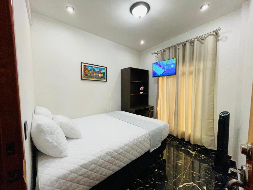 a bedroom with a bed and a television in it at casa Borde Del Lago1 in Panajachel