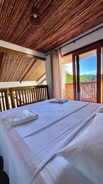 a large white bed in a room with a balcony at Casa dos Pássaros - AR Condicionado nos dois quartos in Lençóis