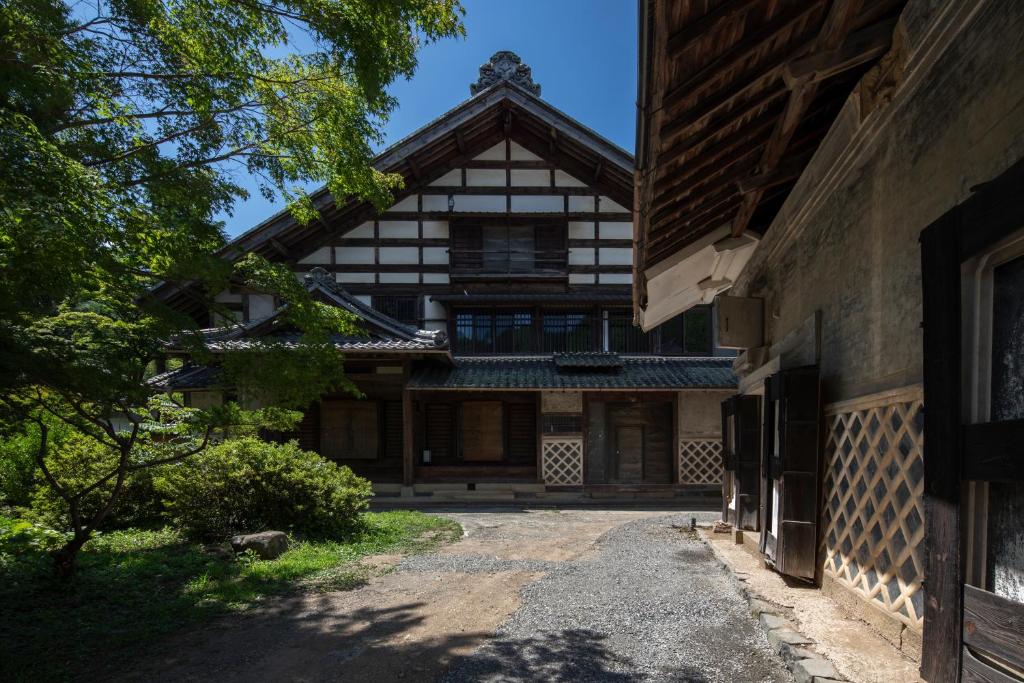 una vista esterna di una casa con un sentiero di Satoyama Villa Honjin a Matsumoto