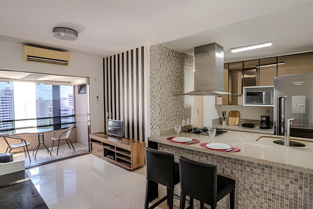 a kitchen with a counter with chairs and a kitchen island at Flat c/ Limpeza Diária | Piscina e Praia - DL1804 in Recife