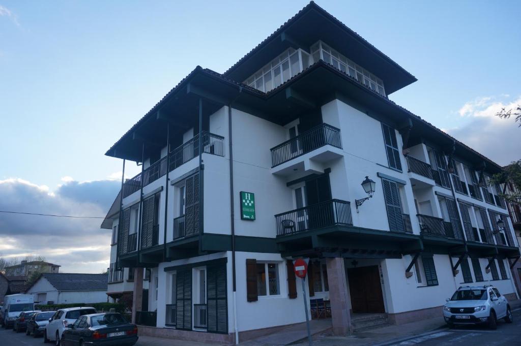 ein weißes Gebäude mit davor geparkt in der Unterkunft Hotel Elizondo in Elizondo