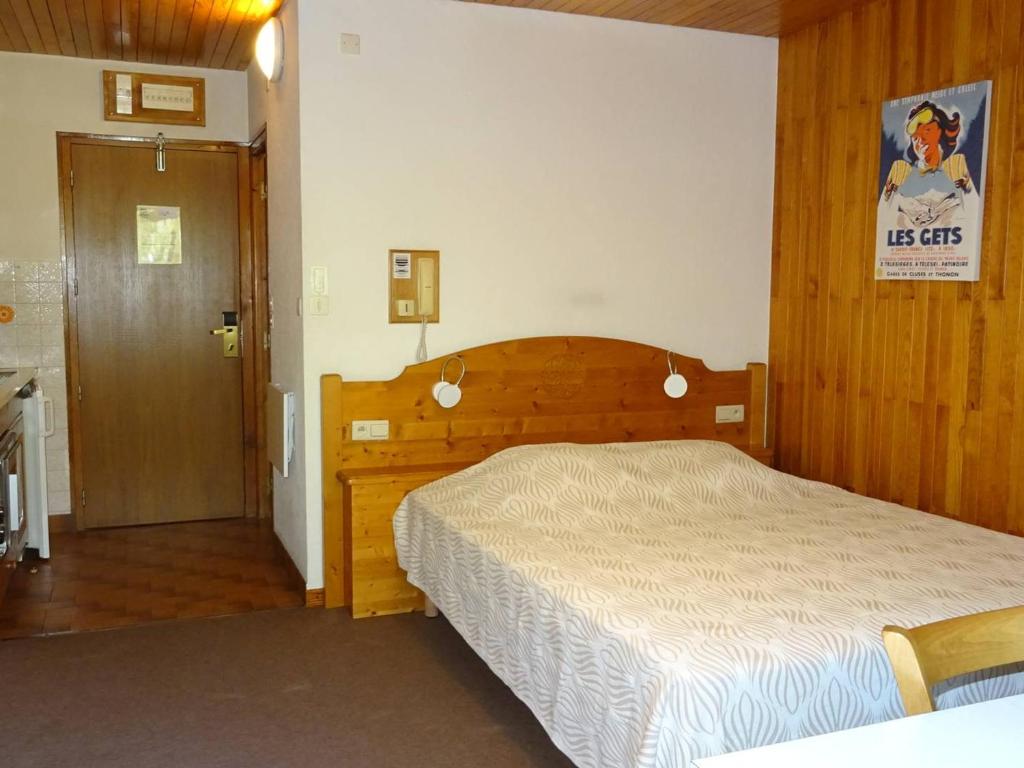 - une chambre avec un lit en bois et une porte en bois dans l'établissement Studio pour 2 avec WiFi - Les Gets Centre - FR-1-802-97, aux Gets