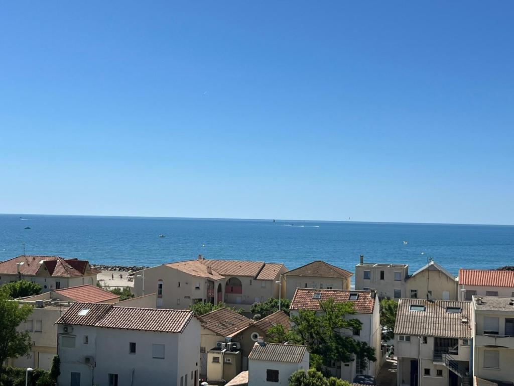 Une ville avec des maisons et l'océan en arrière-plan dans l'établissement Superbe T3 rénové entre port et plage avec parking privé - FR-1-715-109, à Mauguio