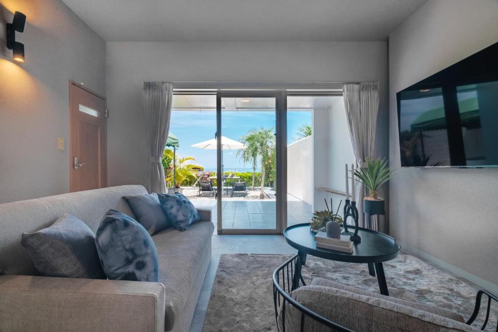 a living room with a couch and a table at Alpha Terrace Motobu Hills in Motobu