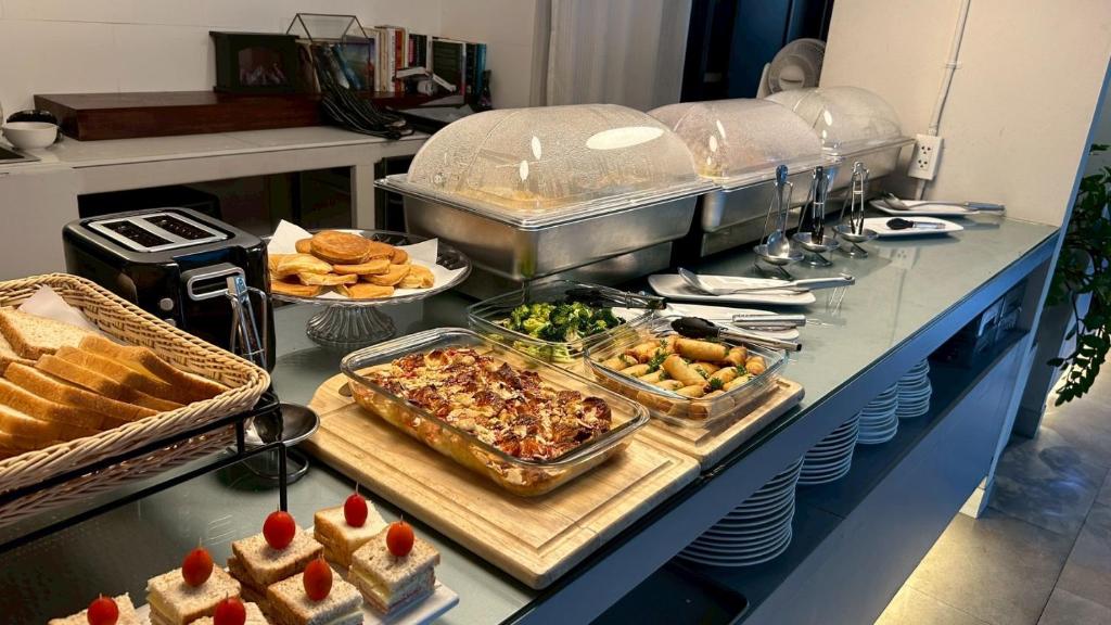 A compact breakfast counter with hot dishes, toast, pastries, and small desserts.